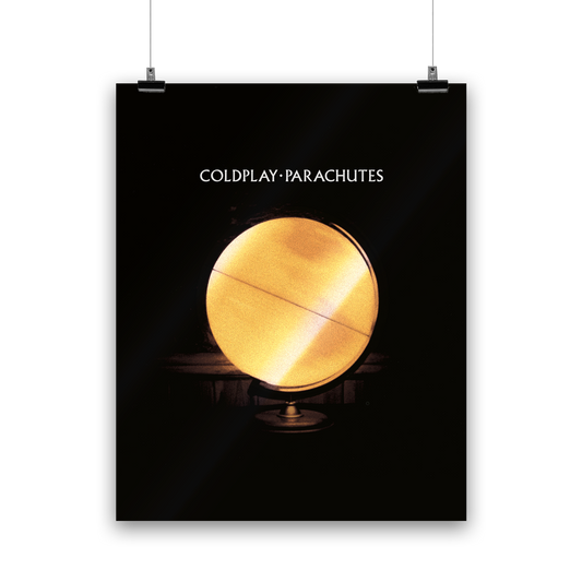 A yellow globe represents the earth, illuminated from within. The center is a bright, luminous yellow; it transitions to a darker, muted red towards the edges, with golden and amber hues. It has reddish patches as continents, and horizontal lines running across as though the globe is spinning. The globe is a lamp, mounted on a stand. It has a black and dark brown background. COLDPLAY, PARACHUTES is written in white